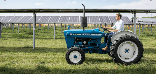 Tractor on solar panel farm home with Boviet PV modules