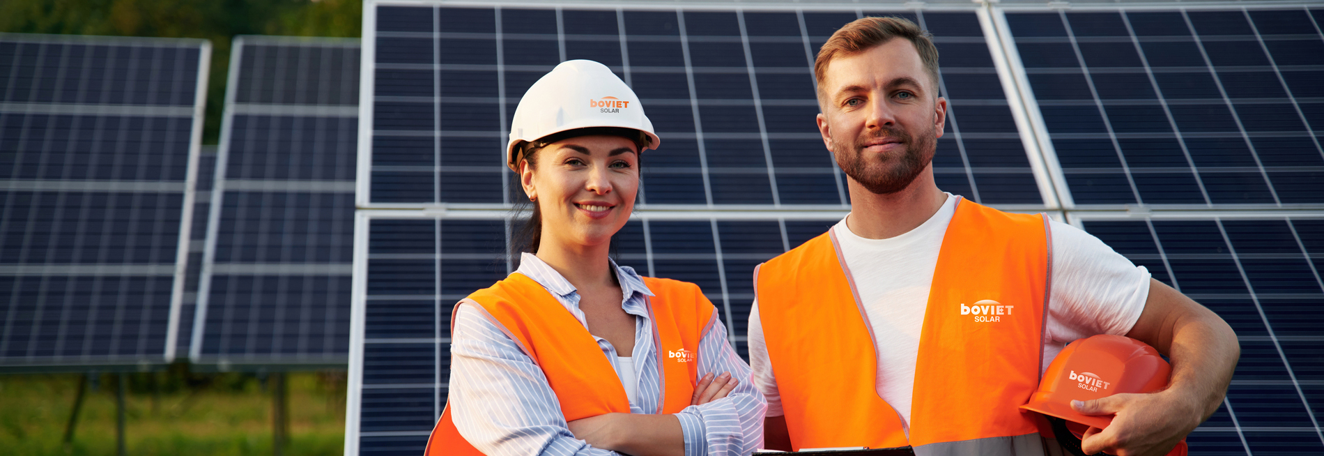 Man And Woman, Workers Are Near Solar Panels, In Uniform